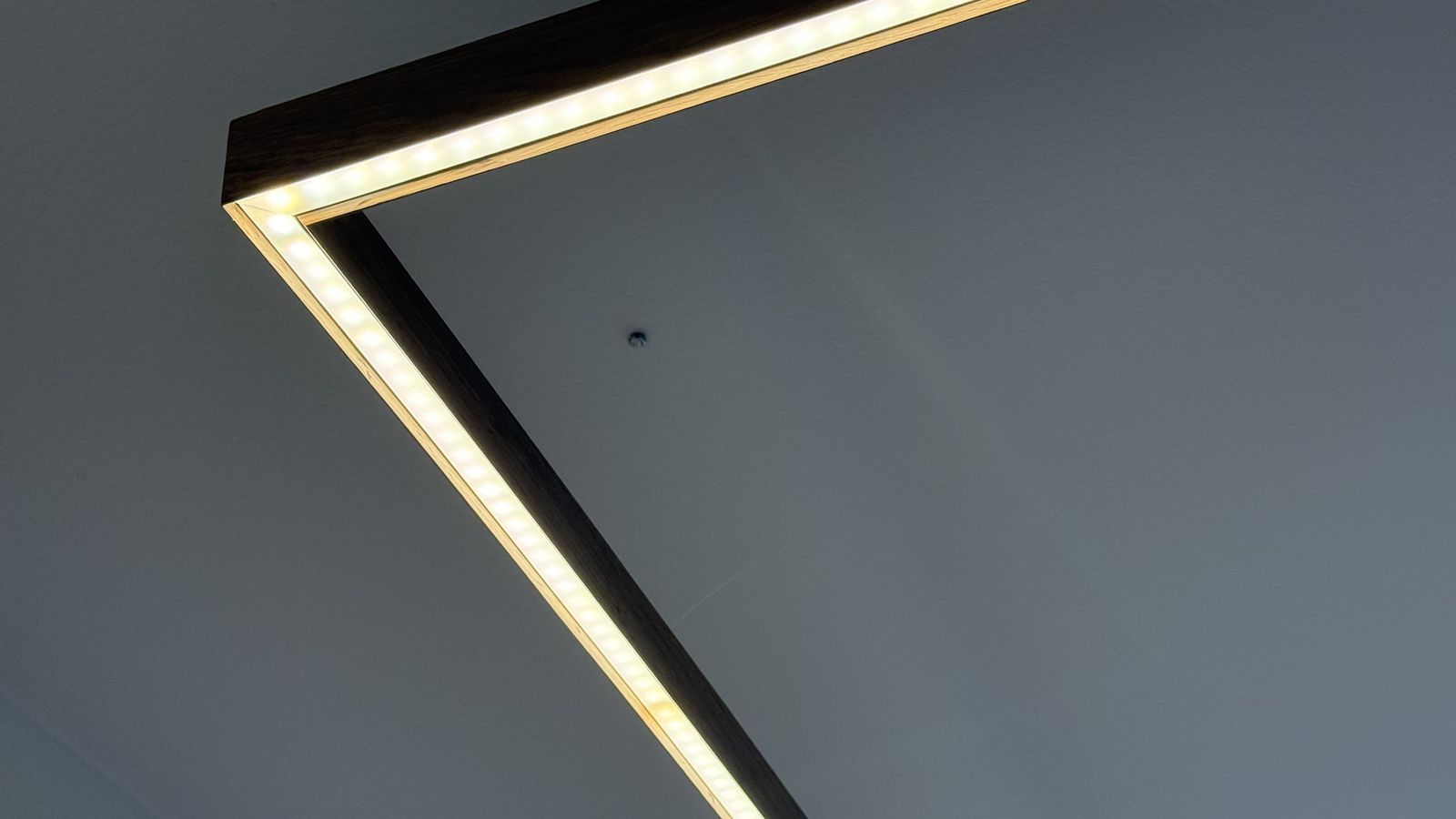Cool white LED edge lighting along the pendant's diagonal corner